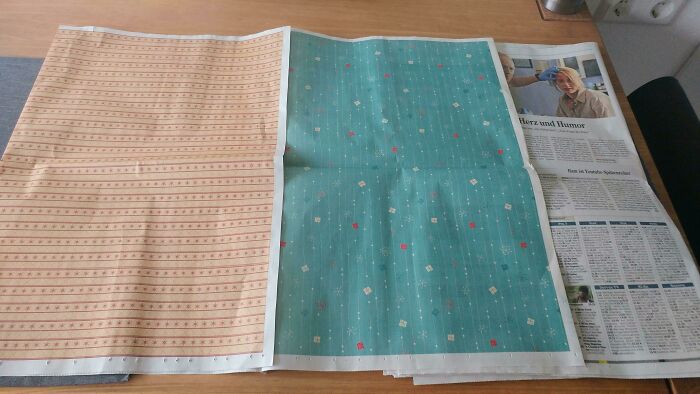 Newspapers with hidden patterns reveal cool product surprises on a table.