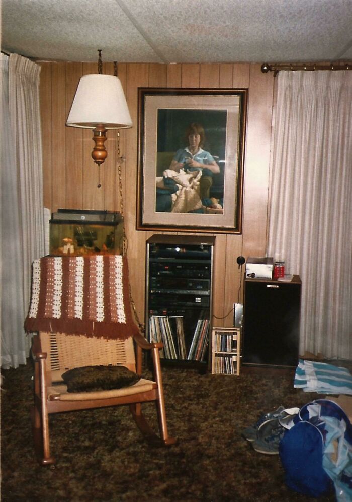 80s nostalgia living room with wood paneling, rocking chair, crochet blanket, and vintage stereo system.