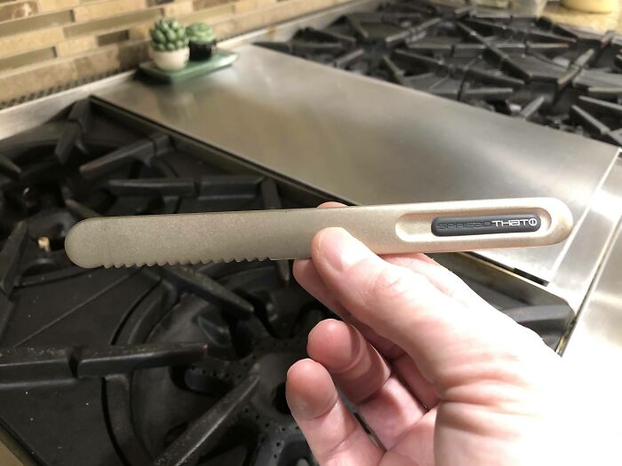 Serrated metal knife with the label "Spread That," showcased as a cool product with surprises in a kitchen setting.