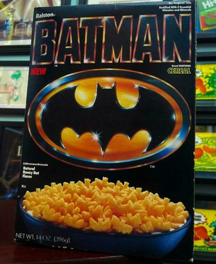 80s nostalgia picture of a Batman cereal box with the iconic bat symbol, showcasing honey nut cereal pieces in a blue bowl.