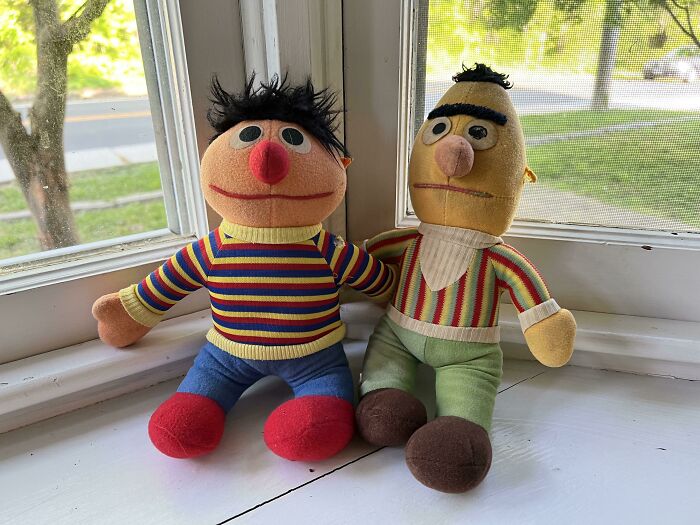 80s nostalgia with plush dolls sitting by a window, dressed in colorful striped shirts.