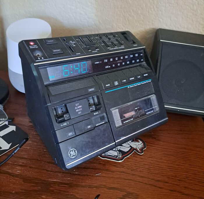 Vintage 80s clock radio cassette player on a wooden table, showcasing classic nostalgia.