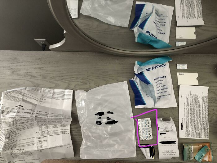 Disorganized pharmacy packaging and medication spread on a table, highlighting local pharmacy issues.