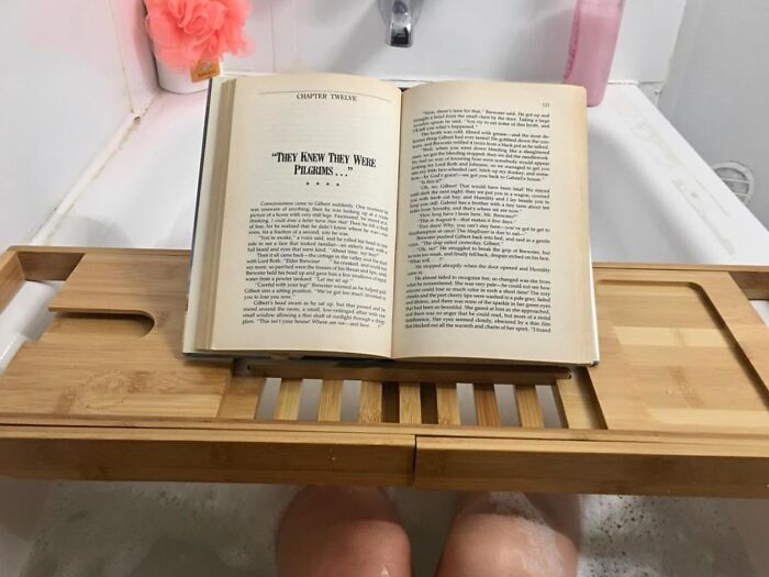 Open book on a bamboo tray over a relaxing bath, perfect for rewarding yourself after a busy day.