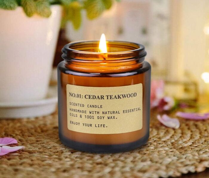 Scented candle in a glass jar labeled "Cedar Teakwood," perfect for rewarding yourself after a busy day.