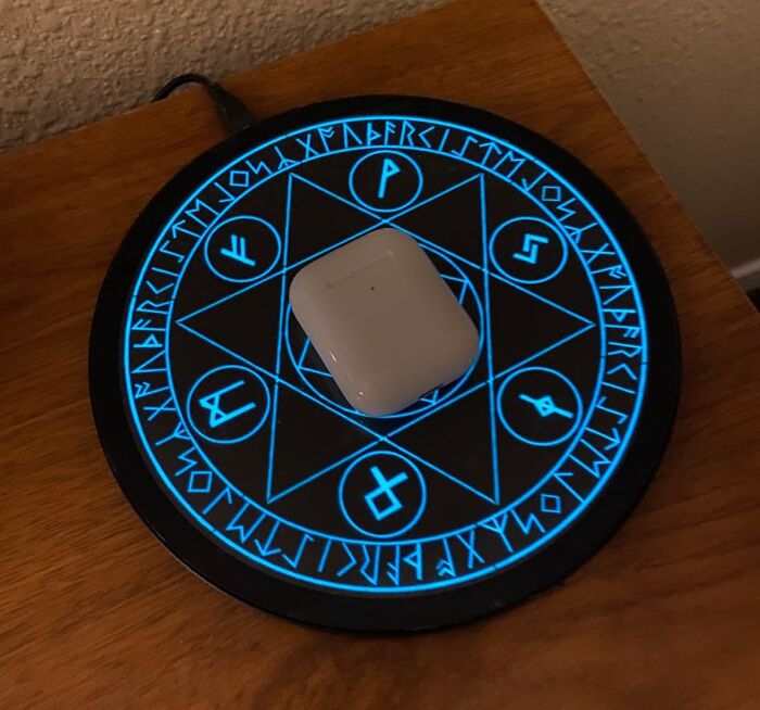 Wireless charger with a futuristic design, featuring glowing symbols, showcasing one of the best gadgets for 2025.