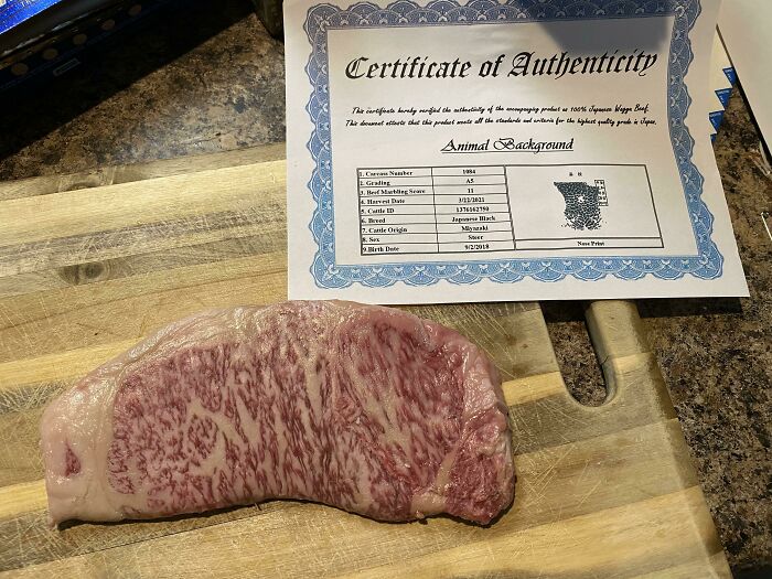 Wagyu beef on a wooden board with a certificate of authenticity, showcasing cool products with surprises.