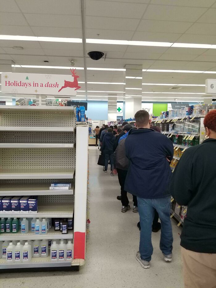 Long line of customers waiting at a local pharmacy, highlighting a common frustration.