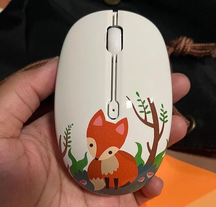 Hand holding a cute fox-themed office mouse, showcasing fun office supplies.