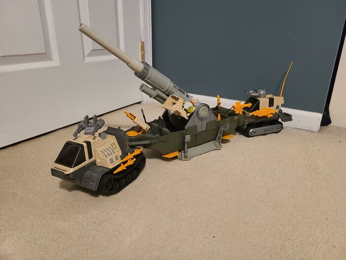 80s nostalgia toys with a military-themed vehicle set on a carpeted floor.