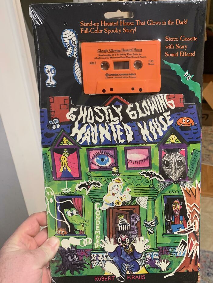 80s nostalgia picture featuring a “Ghostly Glowing Haunted House” cassette with colorful haunted house artwork.