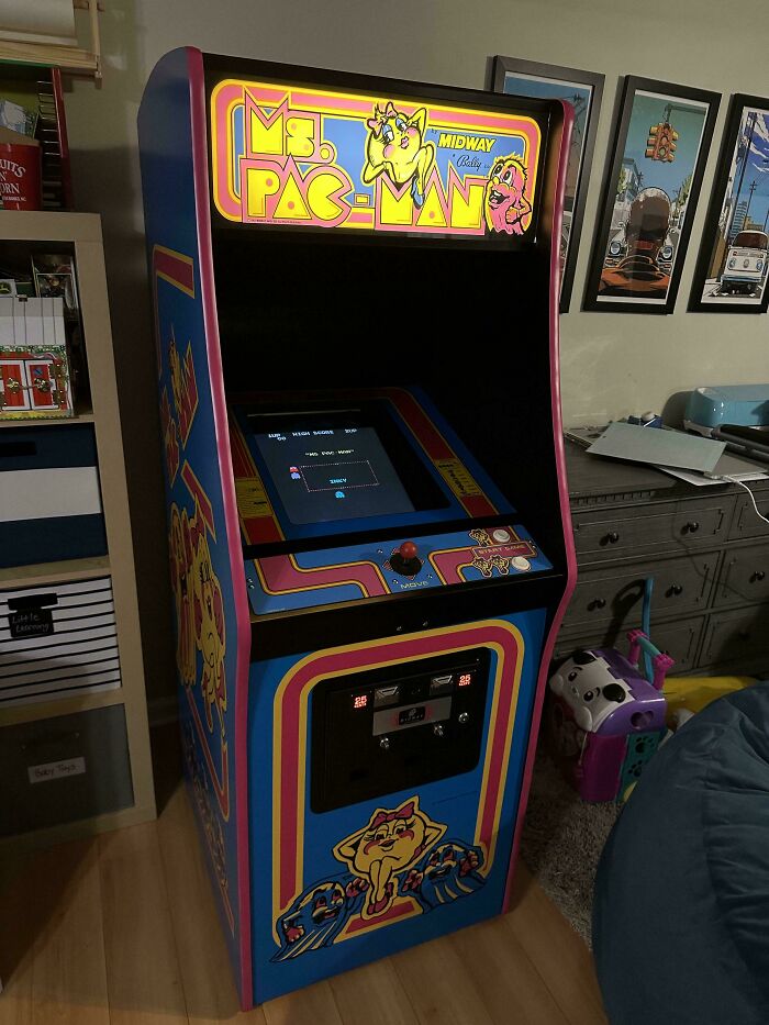 80s nostalgia arcade machine with Ms. Pac-Man graphics in a retro-themed room.