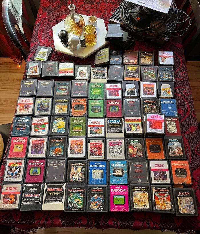 Collection of vintage Atari game cartridges arranged neatly on a table, evoking 80s nostalgia.