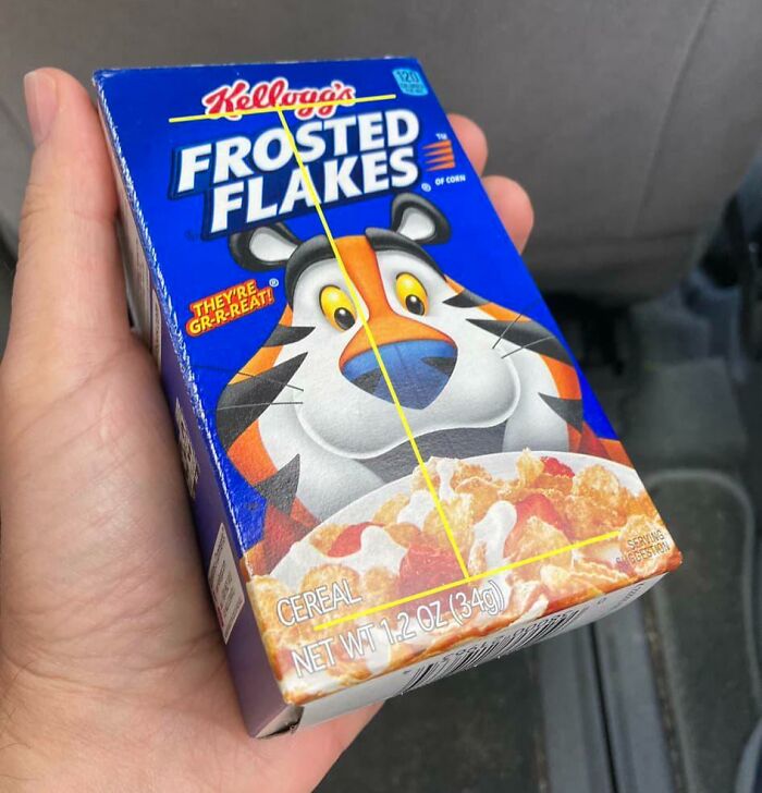 Small box of Kellogg's Frosted Flakes cereal held in a hand, evoking 80s nostalgia.