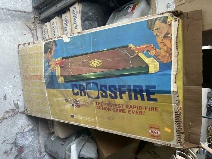 Vintage Crossfire game box, evokes 80s nostalgia with rapid-fire action graphics in a cluttered storage space.