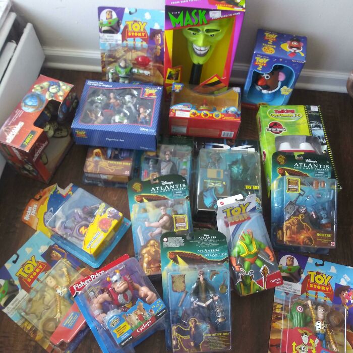 80s nostalgia toys collection featuring The Mask and Toy Story figures in packaging on a wooden floor.