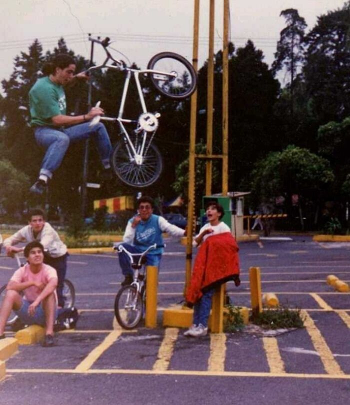 A group of teenagers in the 80s watching a BMX trick in a parking lot, capturing 80s nostalgia and youthful adventure.