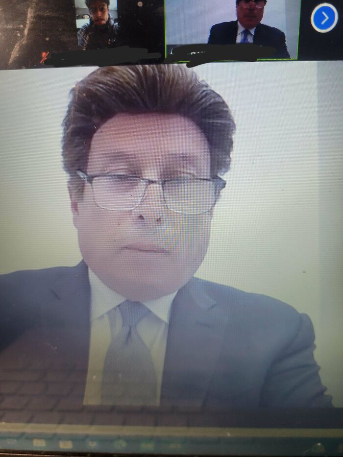 Man in a virtual meeting with a noticeable wig, demonstrating hair accidents humor.