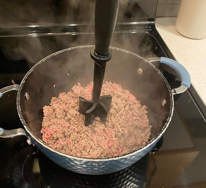 Ground beef cooking in a pot, showcasing a step to get better at cooking.