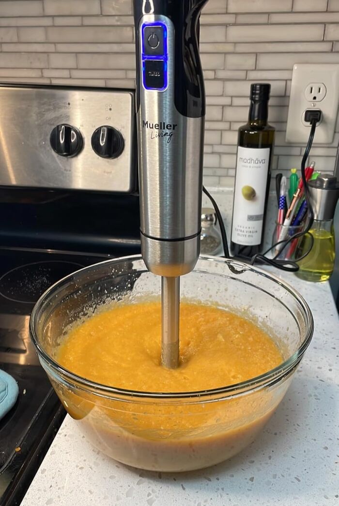 Immersion blender in a bowl of soup on a kitchen counter, promoting better cooking skills.