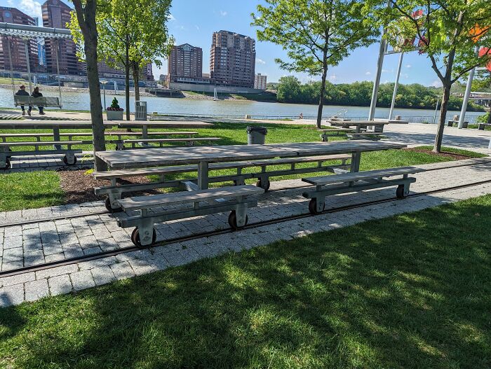 Outdoor movable picnic table on tracks by riverside, highlighting cool products with surprises.