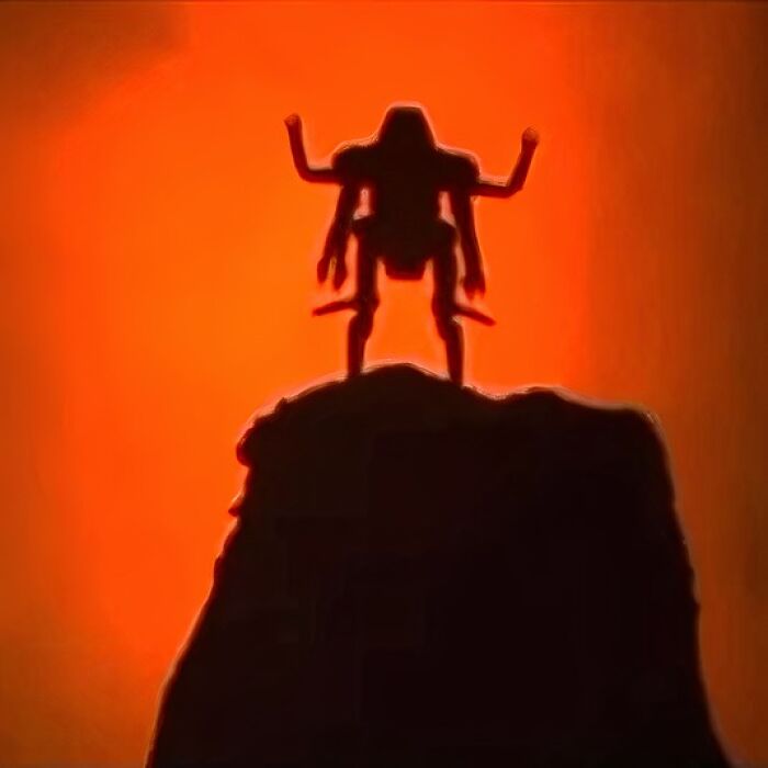 Silhouette of a futuristic robot on a rock against an orange background, capturing Gen X nostalgia.