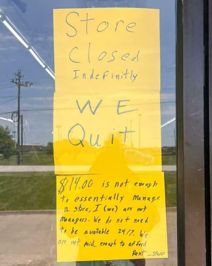 Handwritten sign on store door reading “We Quit," symbolizing people quitting jobs.