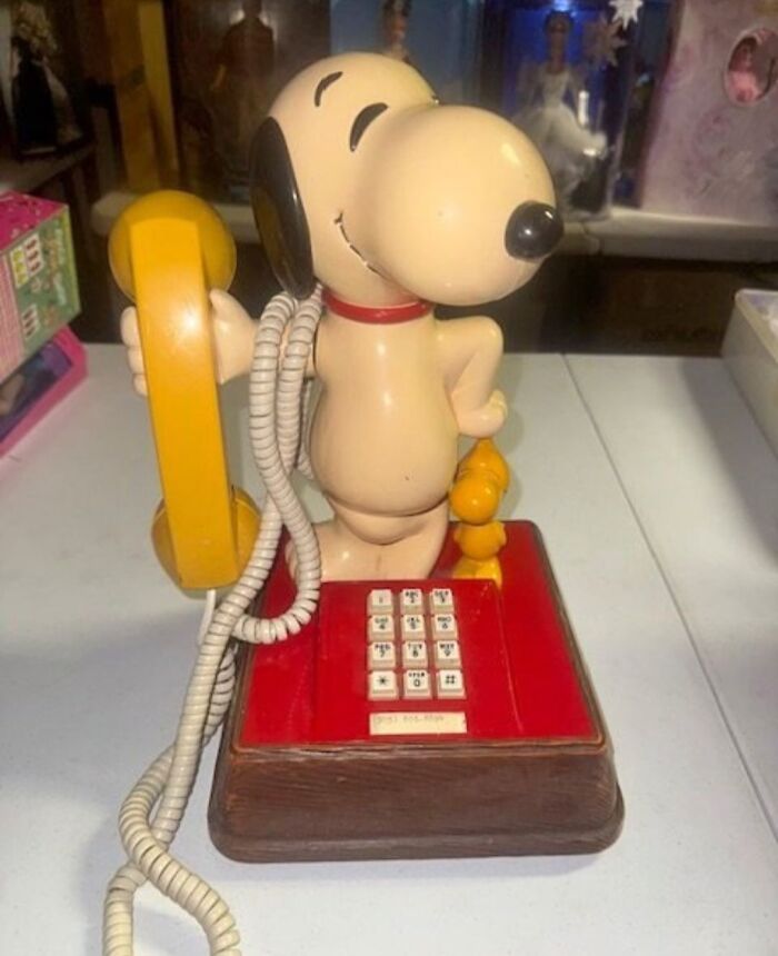 Snoopy phone with yellow receiver, a nostalgic Gen X collectible on a shelf.