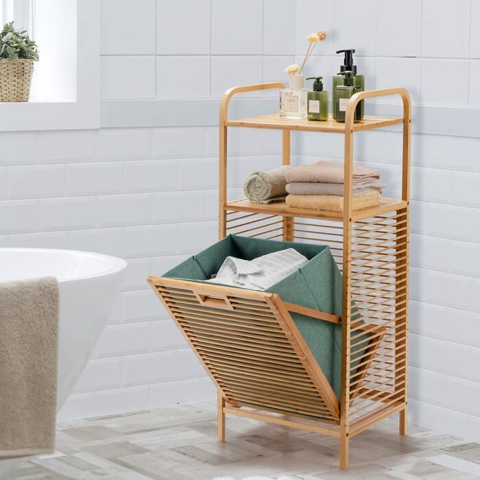 Smart squeeze storage solution with wooden shelves and a laundry basket in a small bathroom setting.