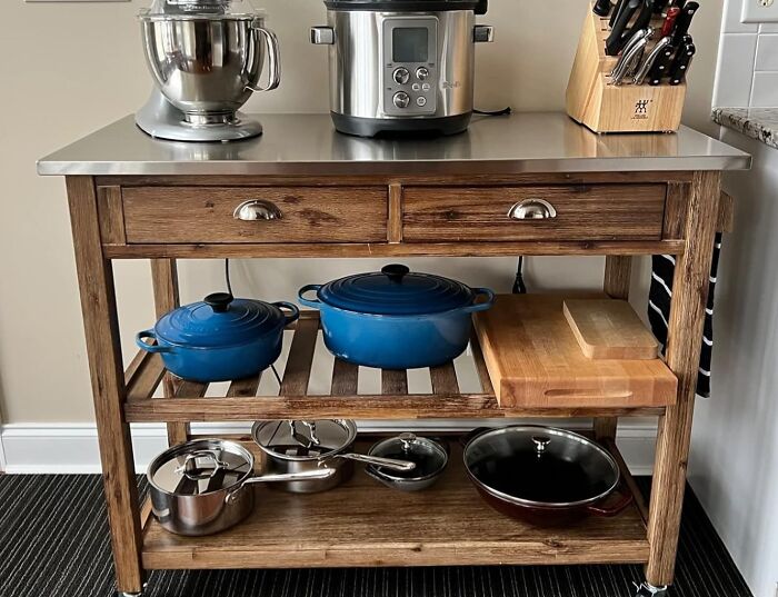 Wooden kitchen cart with smart furniture solutions, featuring appliances and cookware.