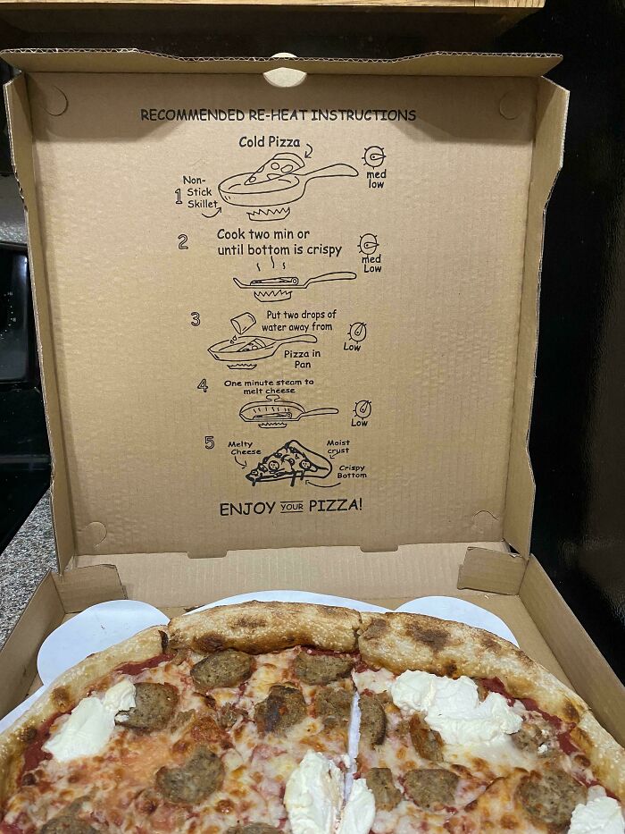 Pizza box with surprise reheating instructions, featuring a baked pizza.