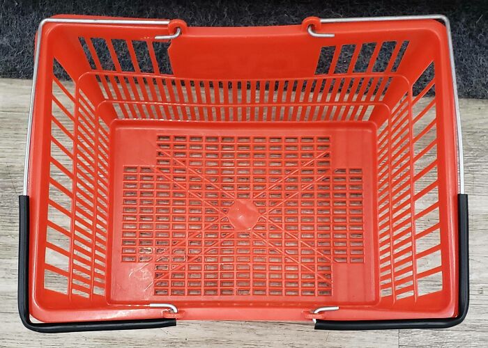 Empty red basket on wooden floor, symbolizing frustration at local pharmacies.