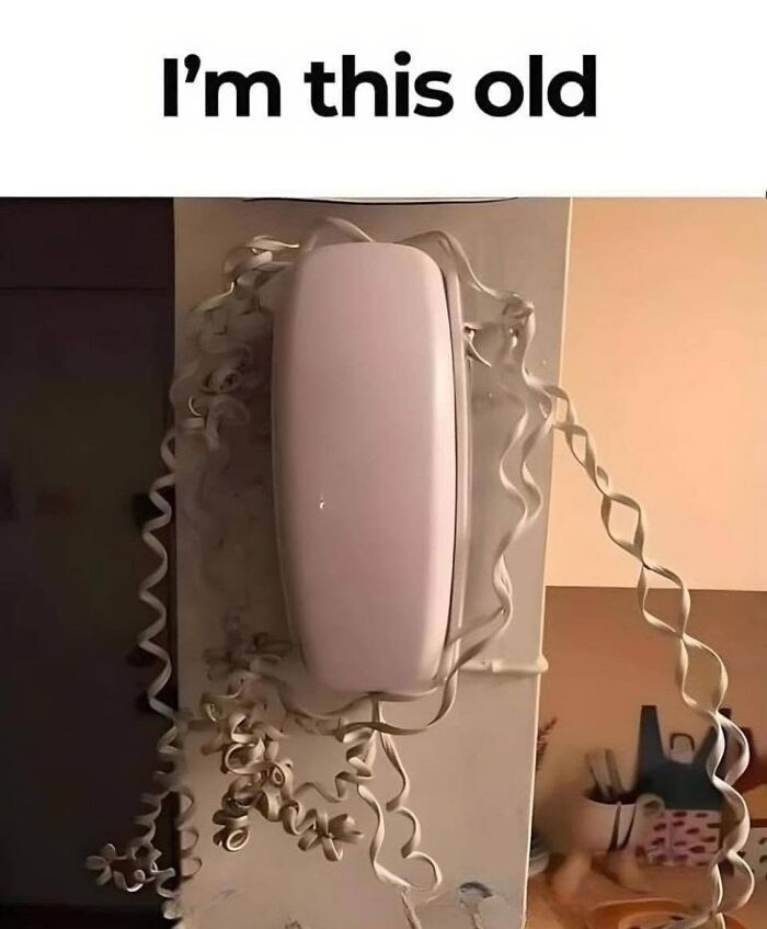 Old rotary phone with tangled cord evokes Gen X nostalgia.