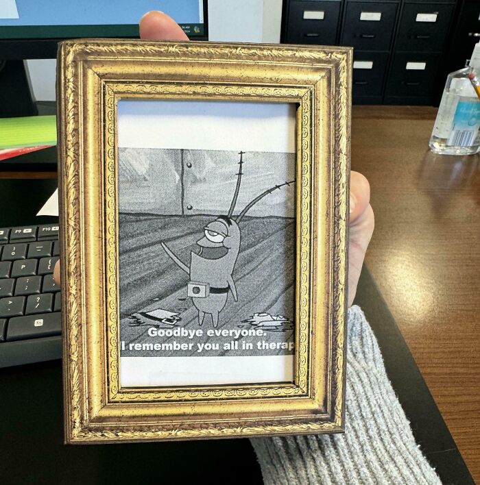 Framed cartoon character with text about quitting jobs held in an office setting.