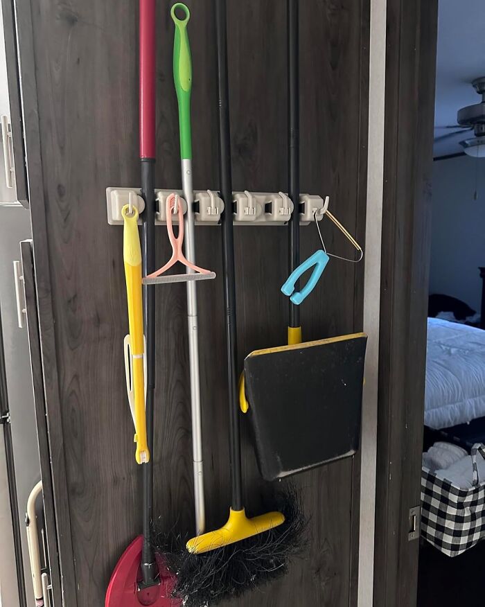 Cleaning tools neatly organized on a wall rack for a more put together home in 2025.