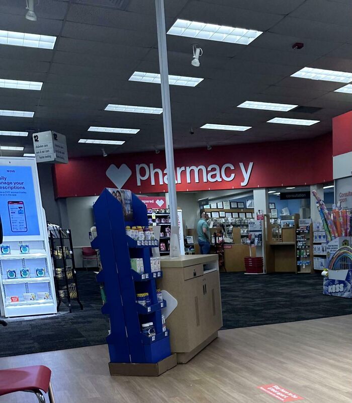 Interior of a local pharmacy showing shelves with products, a sign reading "pharmacy," and a person browsing.