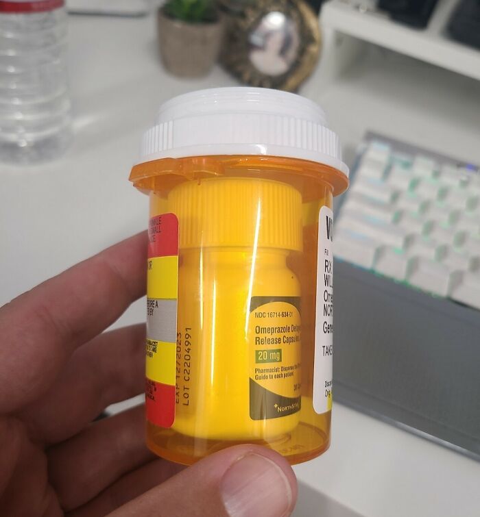 Prescription bottle labeled for omeprazole, highlighting infuriating issues at local pharmacies with medication packaging.