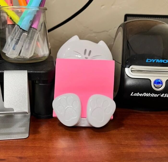 Cat-shaped sticky note holder for elegant desk upgrades in a remote work setup.