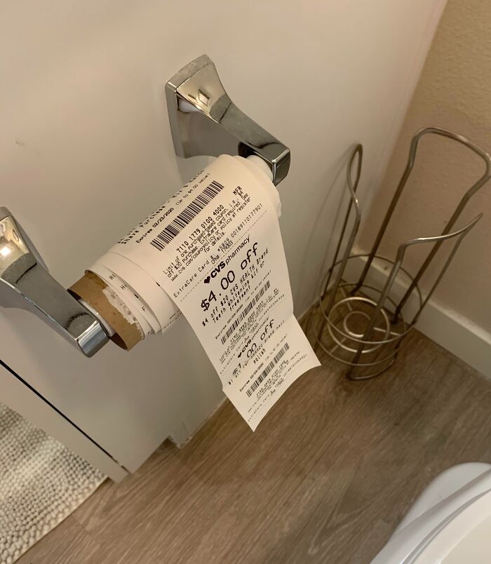 Receipt paper roll with coupon offers on a metallic holder, highlighting infuriating local pharmacies' receipt lengths.