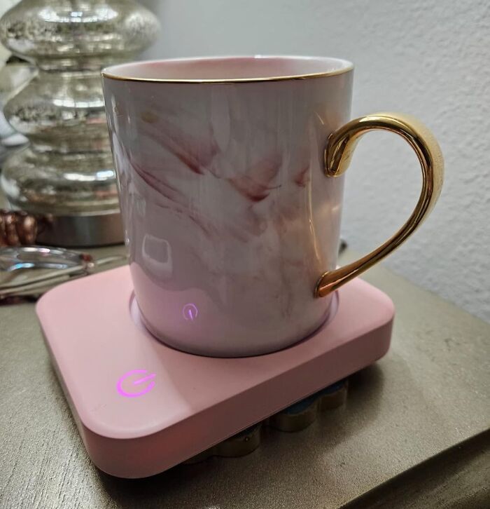 Elegant mug with a golden handle on a pink warmer, perfect for remote workers needing stylish upgrades.