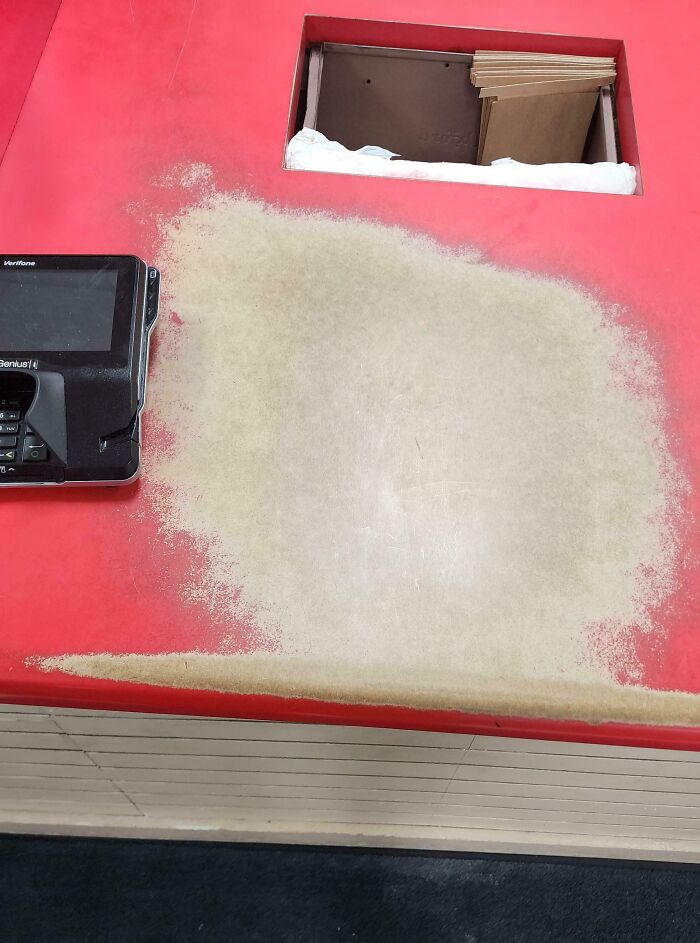 Worn-down red countertop with visible wear marks around a payment terminal, illustrating how time works.