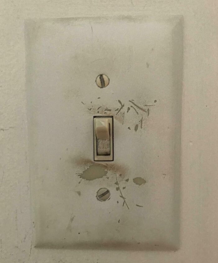 Worn-down light switch with visible scratches and wear, illustrating how time impacts everyday objects.