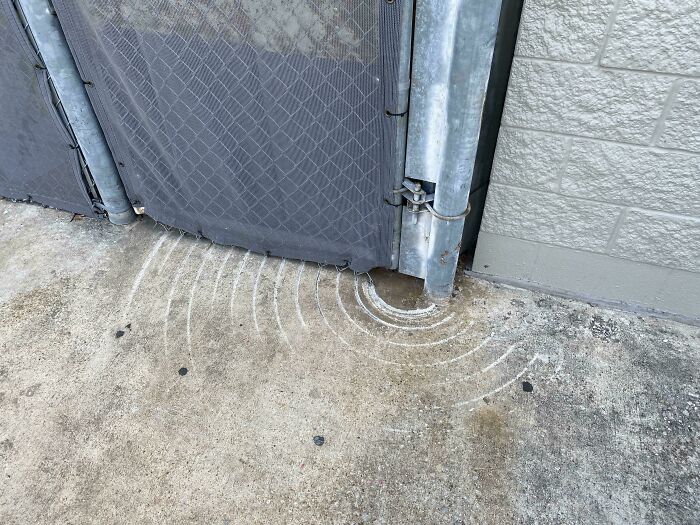 Worn-down concrete with circular marks from a metal gate illustrating how time works.