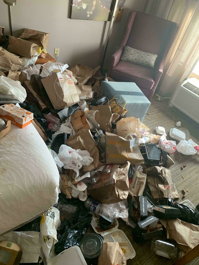 Messy room with piles of trash and fast food bags, showcasing people being complete jerks with their littering habits.