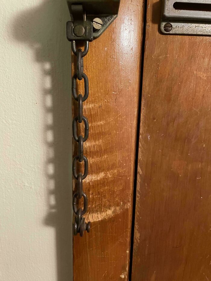 Worn-down door chain showing rust and wear, illustrating the effects of time on everyday objects.