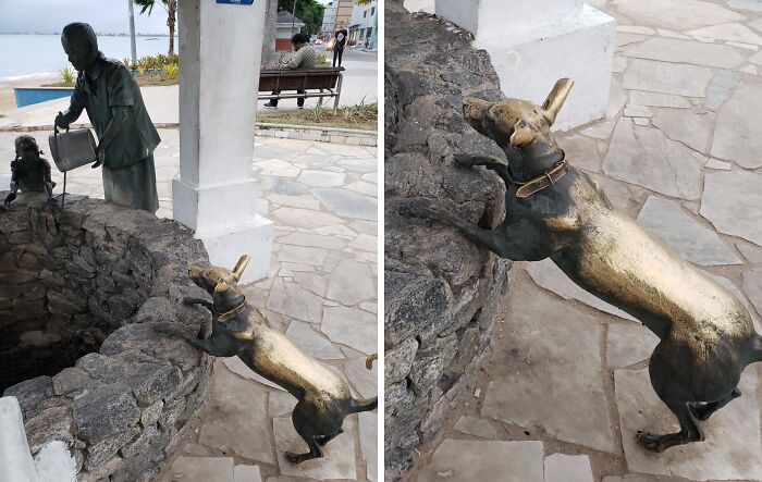 Worn-down statue of a dog at a well, showing the effects of time on its once shiny surface.