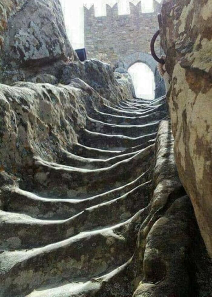 Worn-down stone steps carved into rock, illustrating the effects of time and erosion.