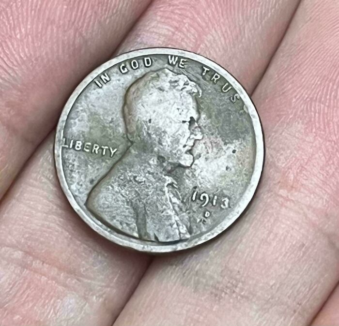 Worn 1913 penny in hand, illustrating the effects of time.