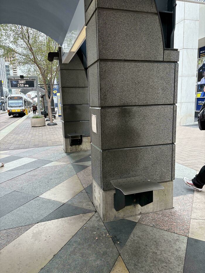 Worn-down seats on concrete pillars at a transit station, illustrating the passage of time.