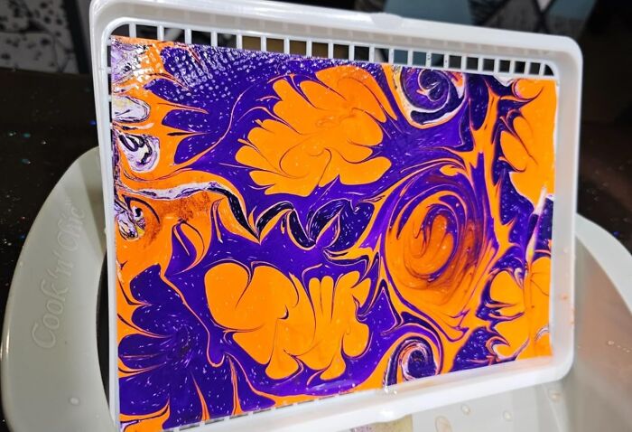 Vibrant marbled art piece with swirling orange and purple patterns, perfect for artistic souls to explore and create.